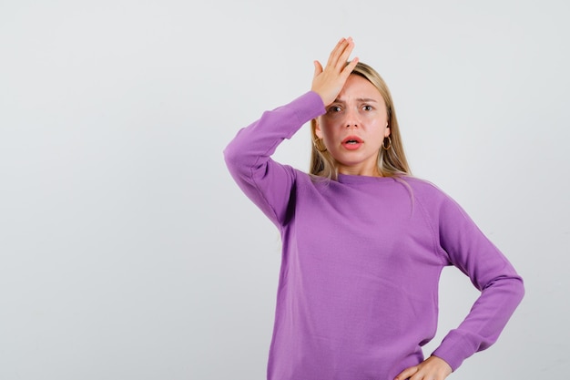 Joven mujer rubia con un suéter morado