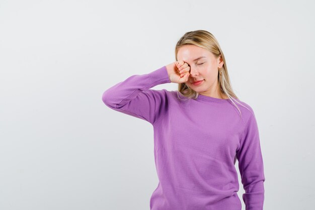 Joven mujer rubia con un suéter morado