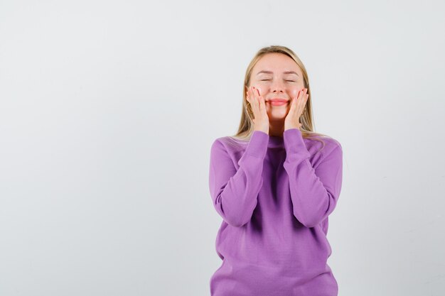 Joven mujer rubia con un suéter morado