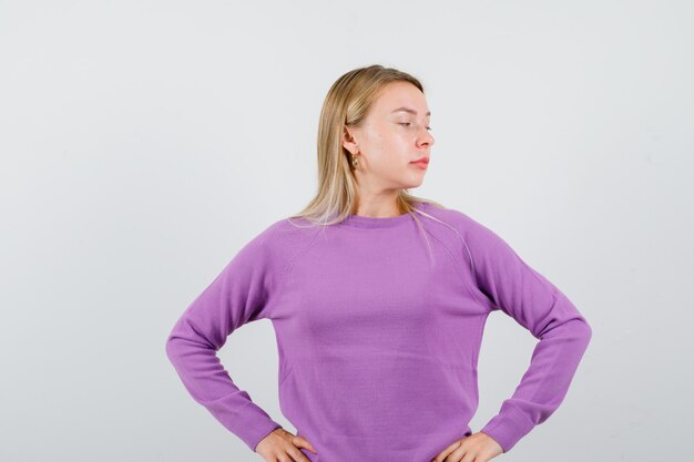 Joven mujer rubia con un suéter morado