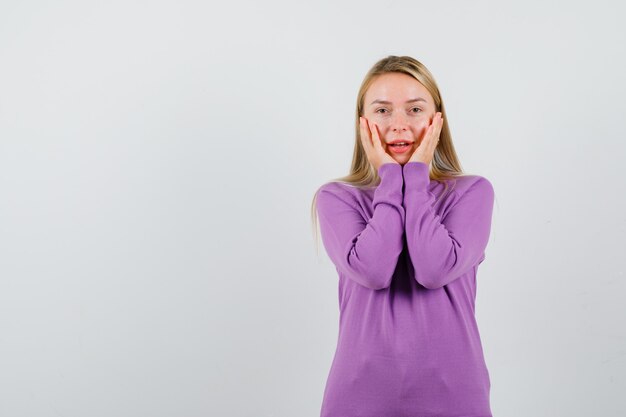 Joven mujer rubia con un suéter morado