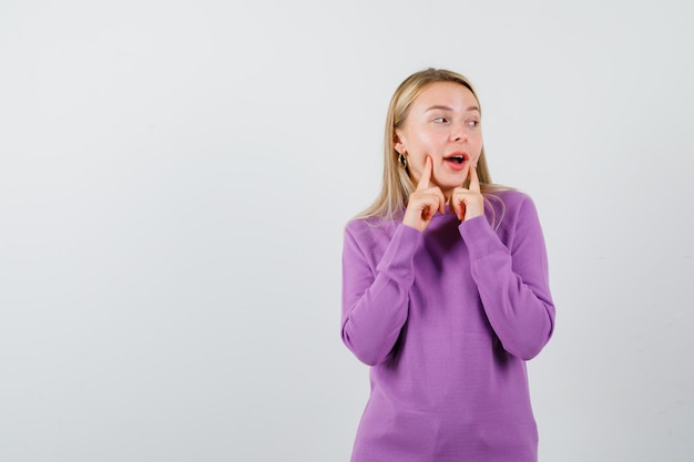 Joven mujer rubia con un suéter morado