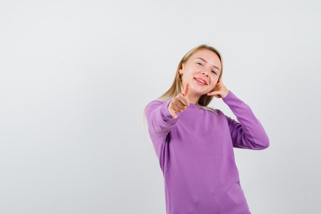 Joven mujer rubia con un suéter morado