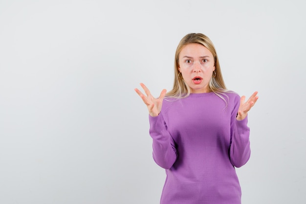 Joven mujer rubia con un suéter morado