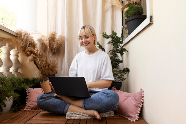 Joven mujer rubia trabajando desde casa en el piso