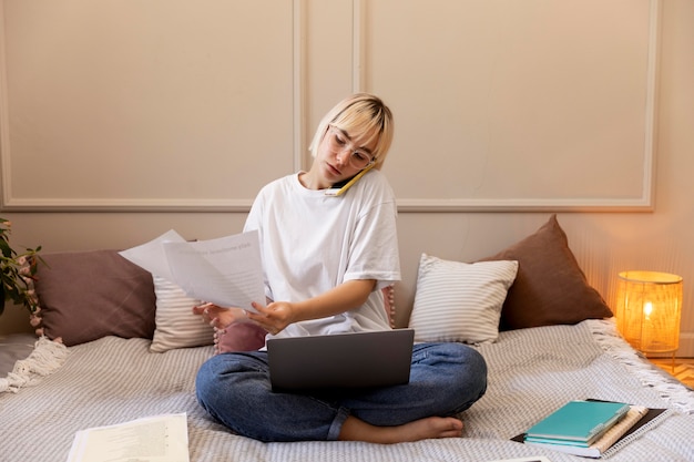 Joven mujer rubia trabajando desde casa en su computadora portátil