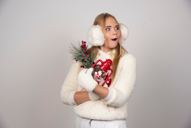 Joven mujer rubia vestida de blanco con regalos en algún lugar.