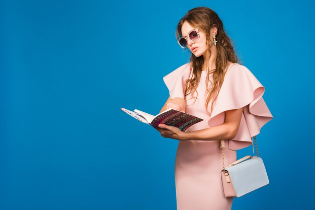 Joven mujer sexy con estilo en vestido rosa de lujo, tendencia de la moda de verano, estilo chic, gafas de sol, moda bloger