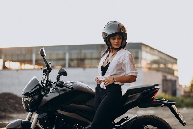 Joven mujer sexy motociclista en bicicleta