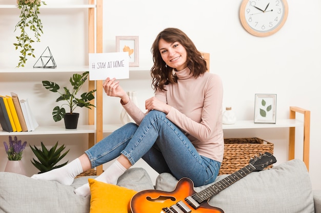 Foto gratuita joven mujer en el sofá con guitarra