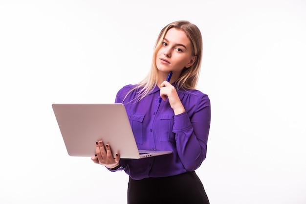 Joven mujer sonriente feliz en ropa casual sosteniendo una computadora portátil y enviando un correo electrónico a su mejor amiga