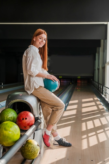 Joven mujer sosteniendo una colorida bola de boliche