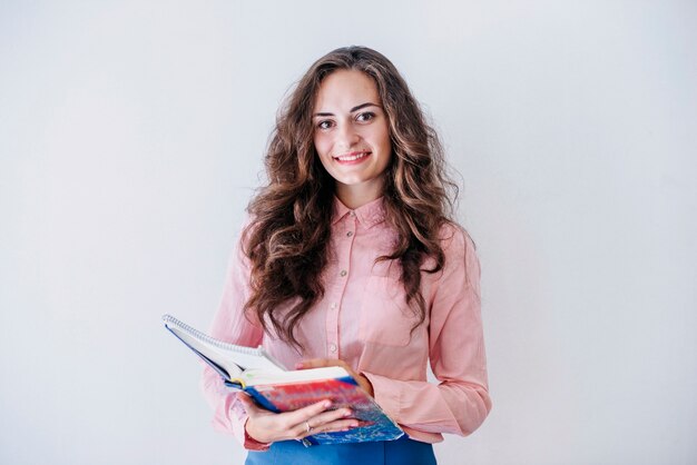 Joven mujer sosteniendo libro abierto en estudio