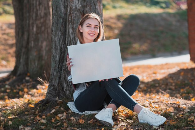 Joven mujer sosteniendo un marco con copyspace