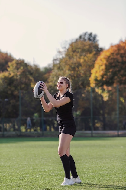 Joven mujer sosteniendo una pelota de rugby