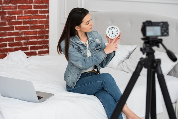 Joven mujer sosteniendo un reloj