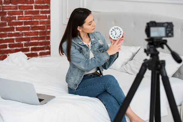 Joven mujer sosteniendo un reloj