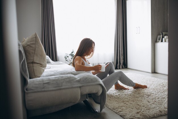 Joven mujer tomando café en casa