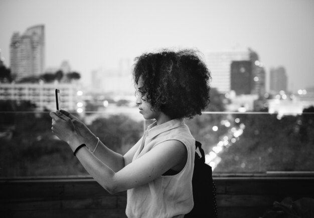 Joven mujer tomando una foto en el paisaje urbano