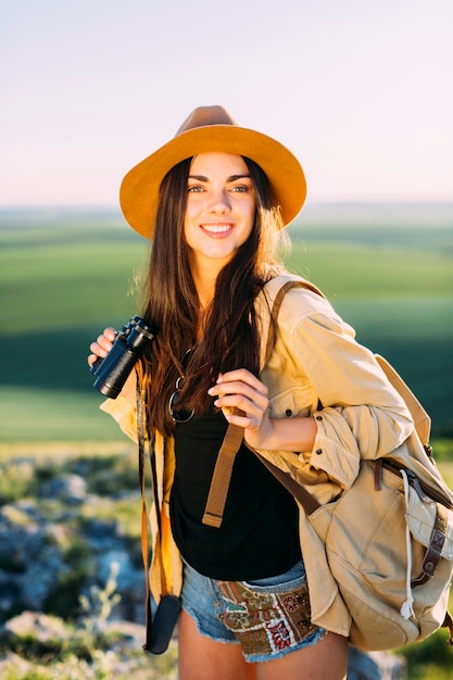 Joven mujer viajero con mochila y binoculares