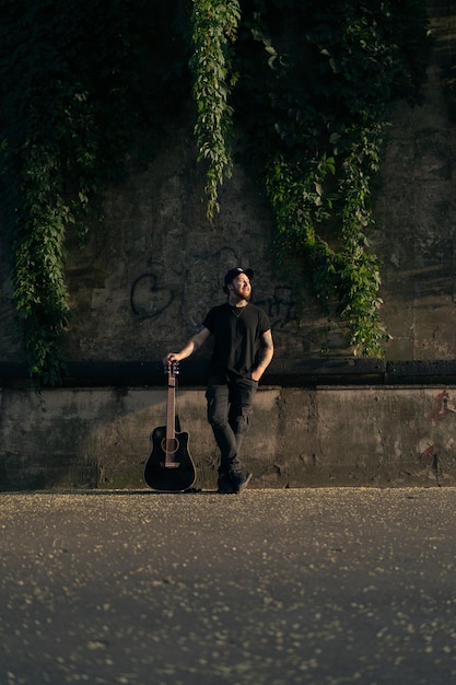 joven músico callejero toca la guitarra y canta. Concepto de música callejera.