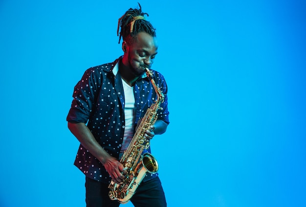 Joven músico de jazz afroamericano tocando el saxofón