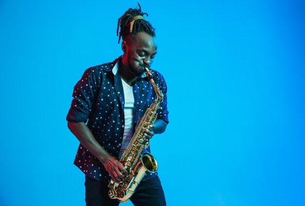 Joven músico de jazz afroamericano tocando el saxofón