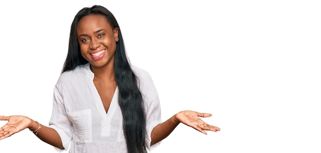 Foto gratuita joven negra con ropa informal sin idea y expresión confusa con los brazos y las manos levantados. concepto de duda.