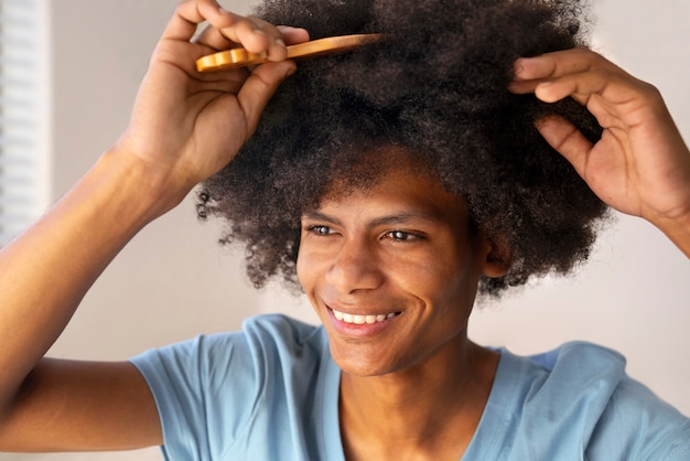 Foto gratuita joven negro cuidando el cabello afro