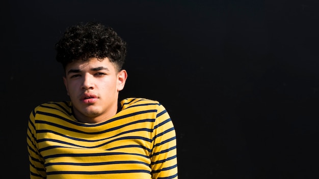 Joven negro con peinado fresco en camisa a rayas