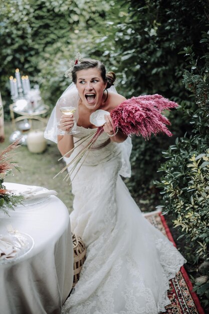 Joven novia feliz sonriendo afuera con ramo