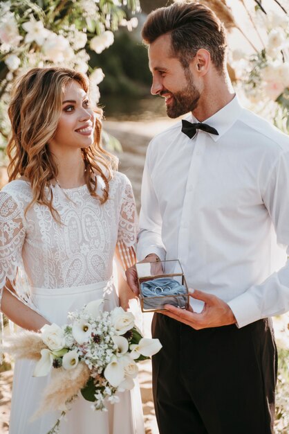 La joven novia y el novio con una boda en la playa