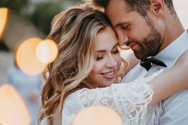 La joven novia y el novio con una boda en la playa