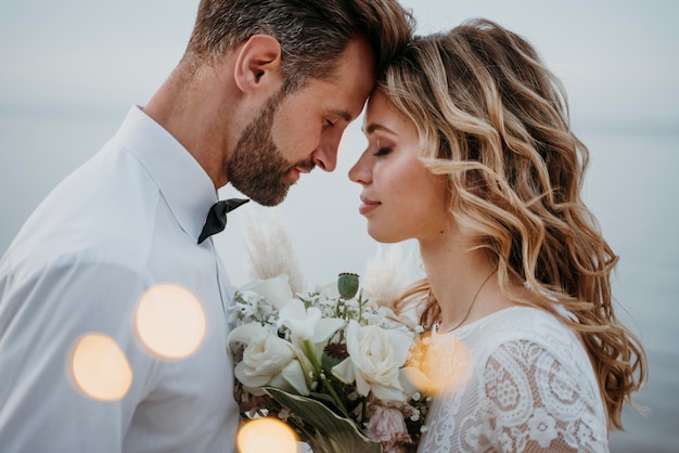 La joven novia y el novio con una boda en la playa