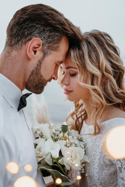 La joven novia y el novio con una boda en la playa