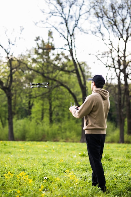 Joven operando un dron con control remoto al aire libre