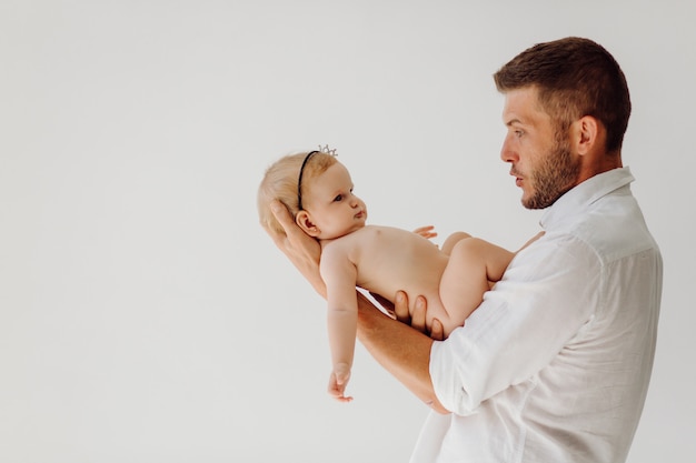 Joven padre con hermoso bebé pequeño en sus brazos