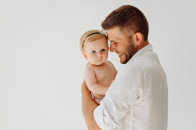 Joven padre con hermoso bebé pequeño en sus brazos