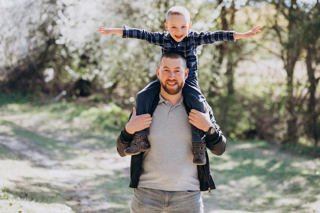 Foto gratuita joven padre con hijo pequeño en el bosque