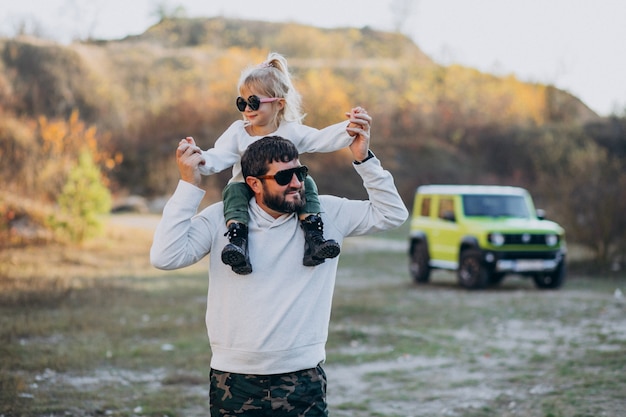 Joven padre de moda con su pequeña hija sentada sobre los hombros