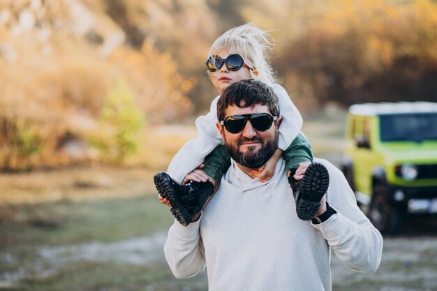 Joven padre de moda con su pequeña hija sentada sobre los hombros