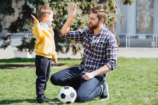 Joven padre y su pequeño hijo dando cinco