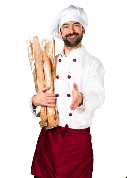 Joven panadero sosteniendo un poco de pan y hacer un trato