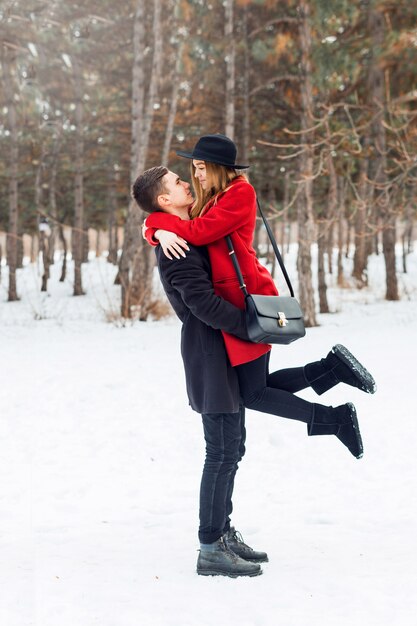 Joven pareja abrazándose en un campo cubierto de nieve