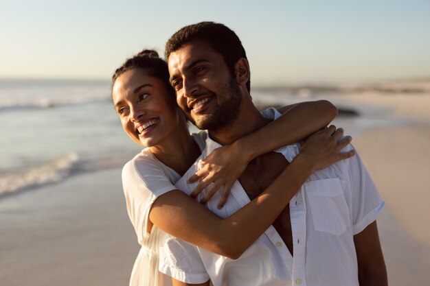 Joven pareja abrazándose en la playa