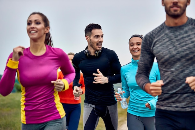 Joven pareja atlética feliz corriendo maratón y hablando entre ellos