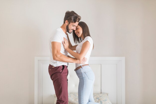 Joven pareja bailando en la cama