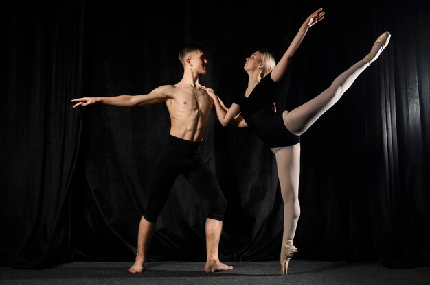 Joven pareja de ballet bailando y posando