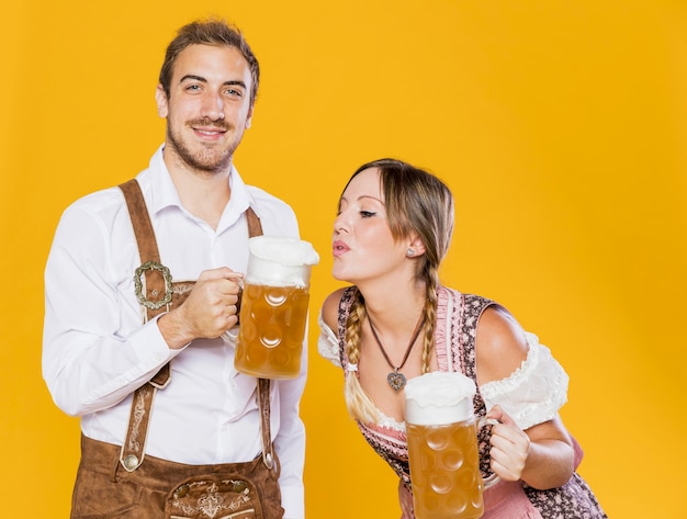 Joven pareja bávara con jarras de cerveza