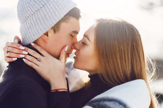 Joven pareja besándose en un día nevado